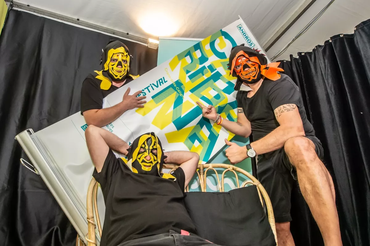 TicTacTec au Caribana Festival – Crans-près-Céligny, 2019 Les DJs masqués de TicTacTec posent devant un panneau du Caribana Festival à Crans-près-Céligny en 2019.